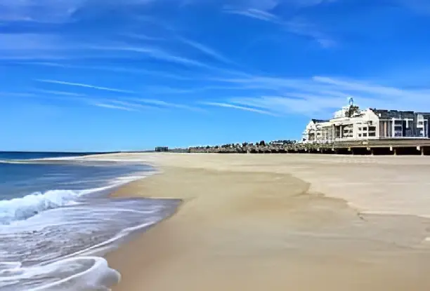 A beach with waves coming in from the ocean.