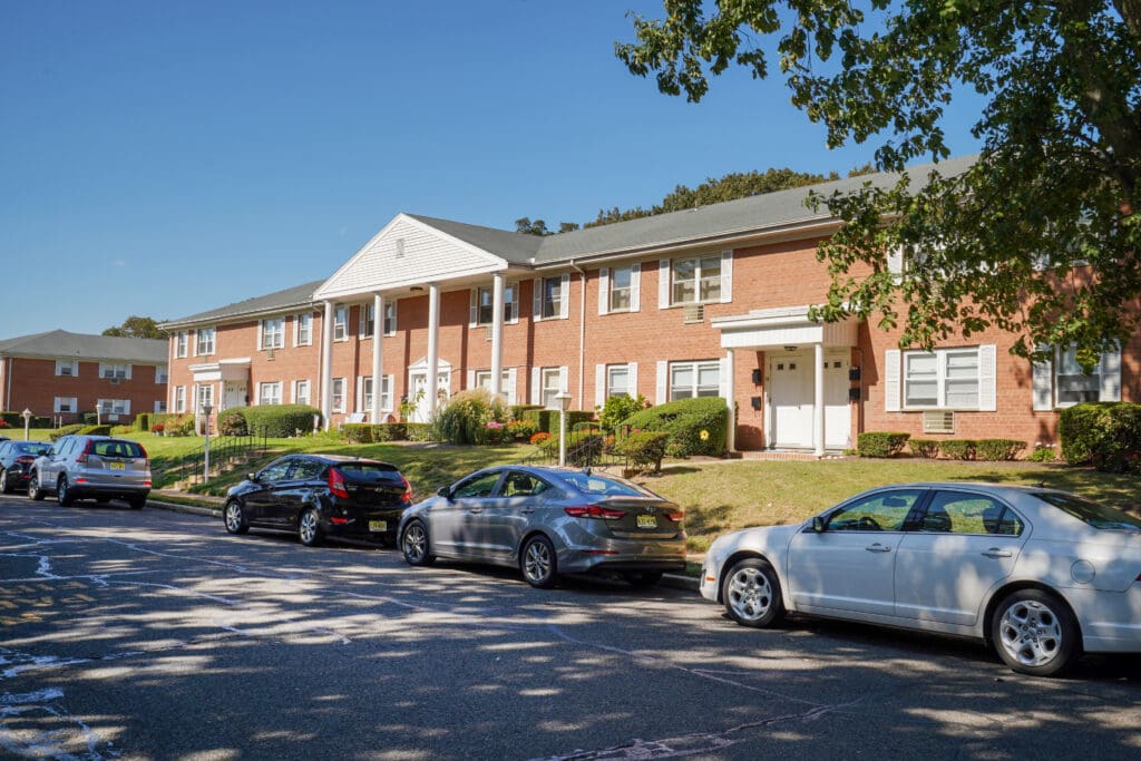 A row of parked cars in front of a brick building.