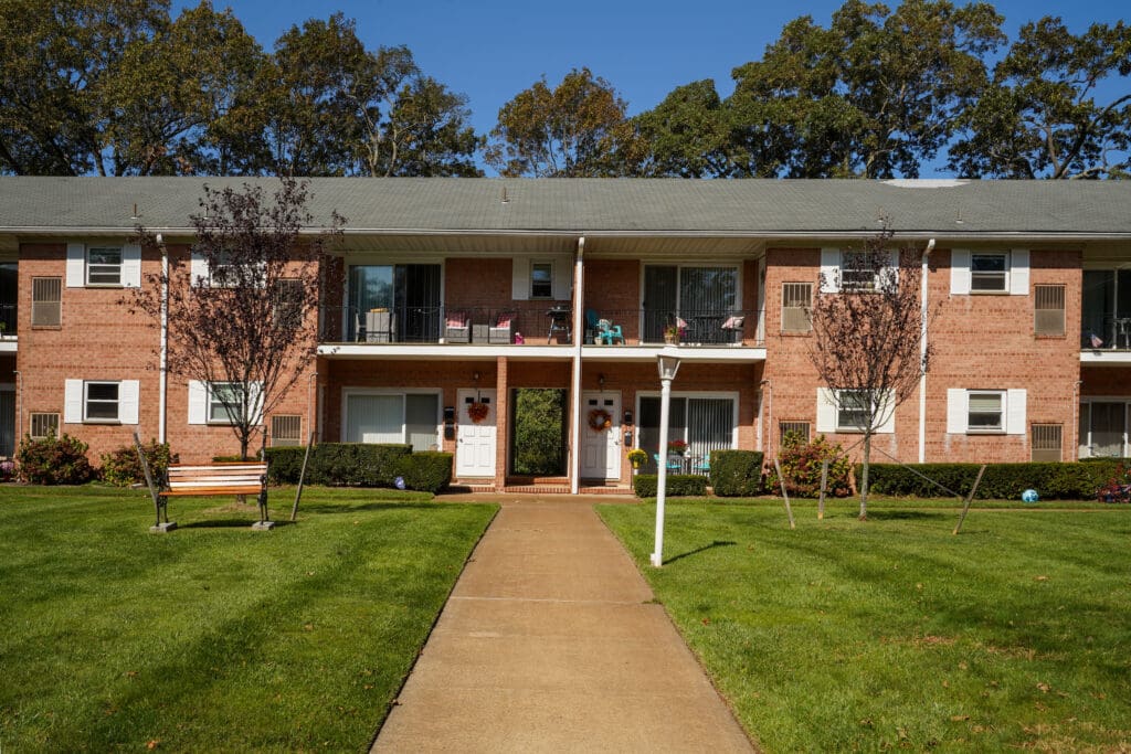 A building with a walkway and trees in the background.