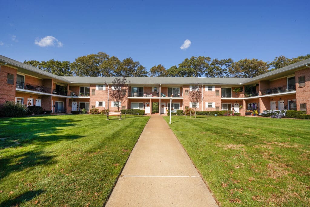 A walkway leading to the front of an apartment complex.