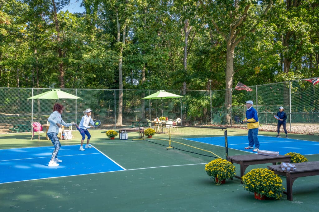 A group of people playing tennis on the court