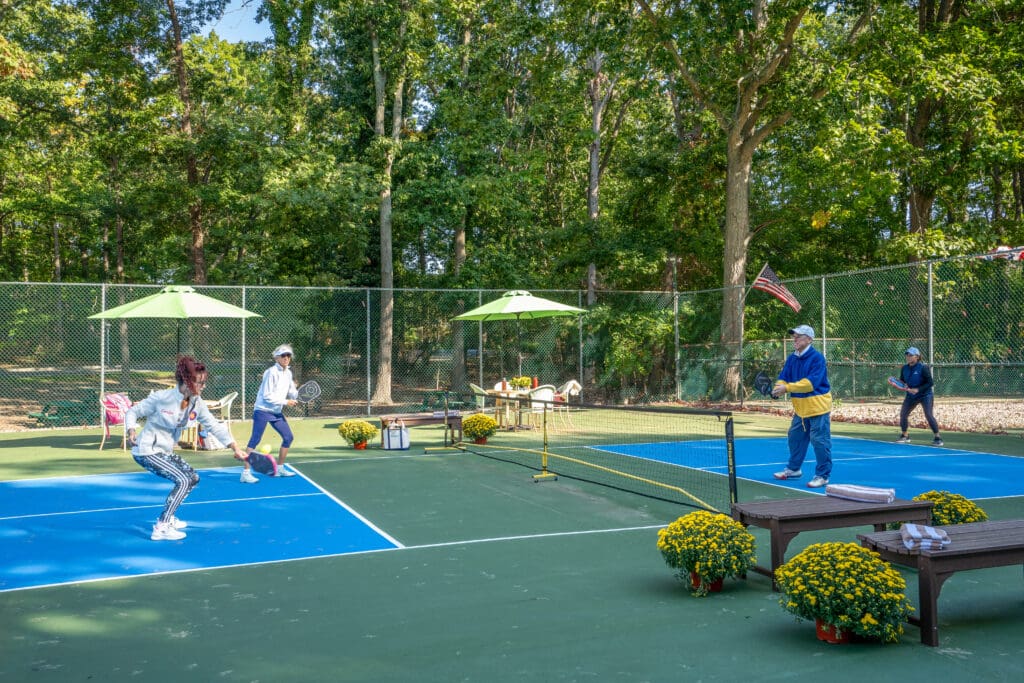 A group of people playing tennis on a court.