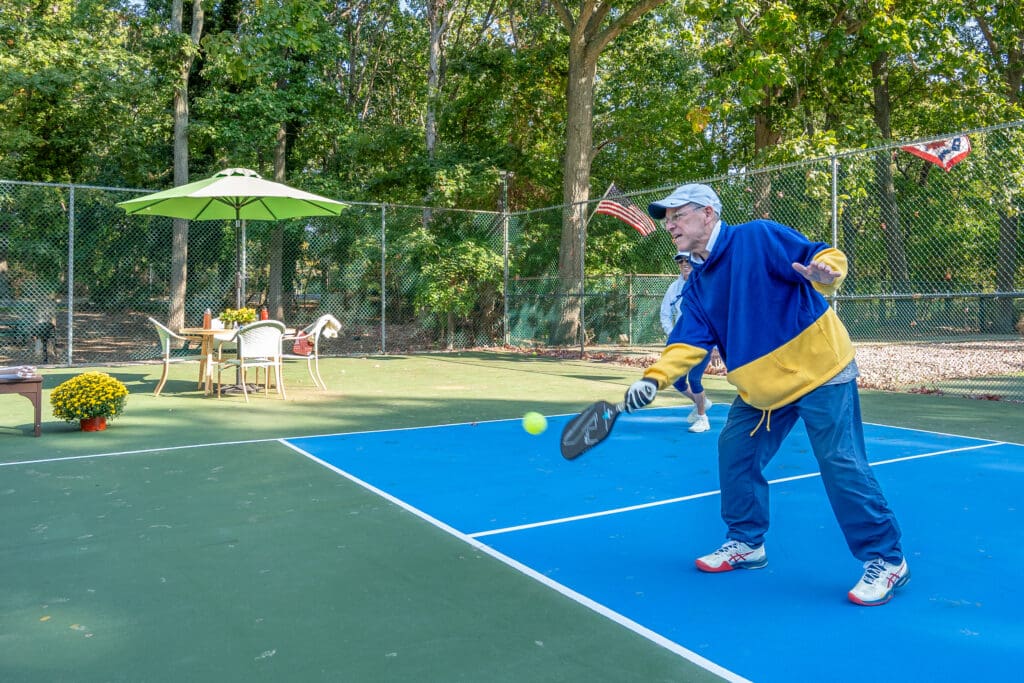 A man swinging at a tennis ball with his racket.