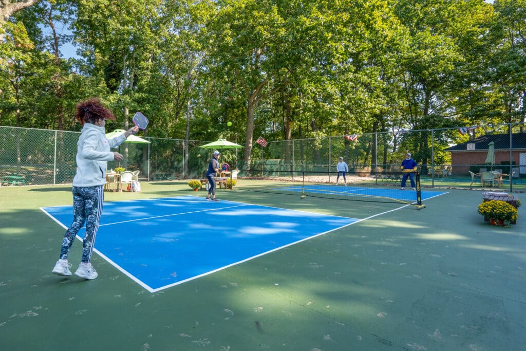 A group of people playing tennis on a court.