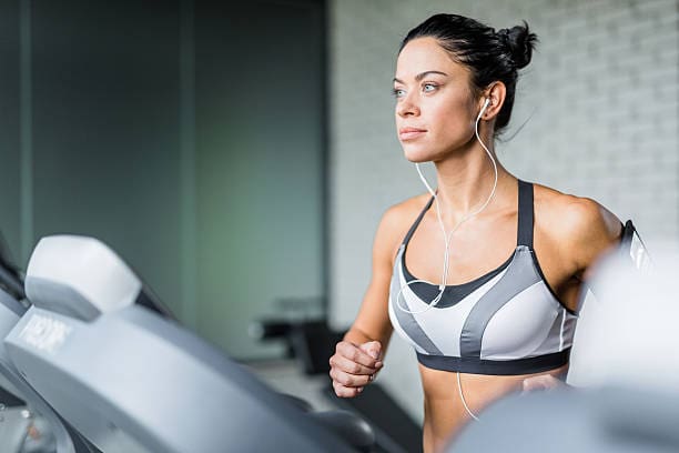 A woman is running on the treadmill in her gym.