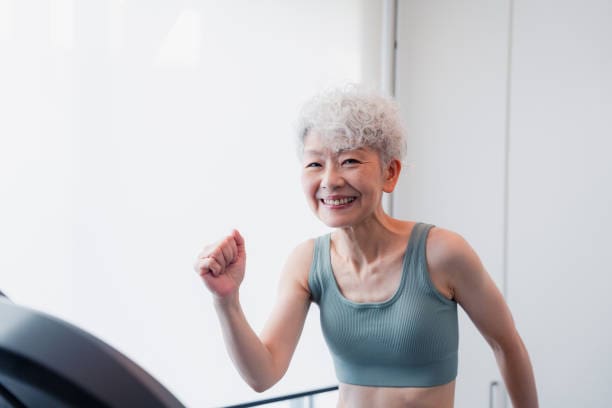 A woman in a blue top is smiling